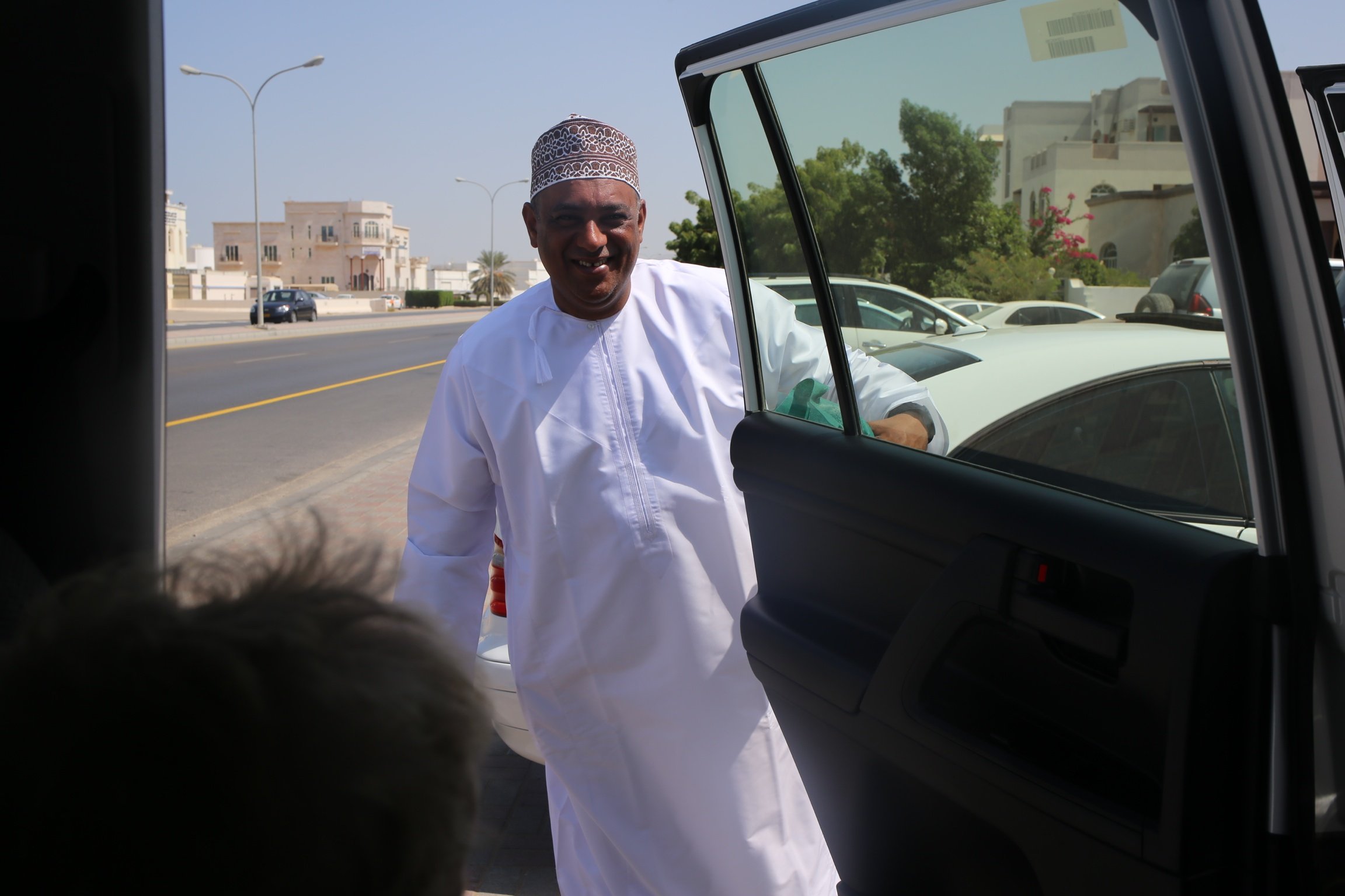 Familienreise_Oman_Mann oeffnet Autotuer
