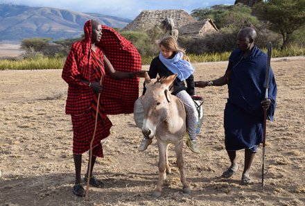Tansania Familienreise - Tansania Family & Teens individuell - Ngorongoro Krater - Mädchen auf Esel in Begleitung von Massai