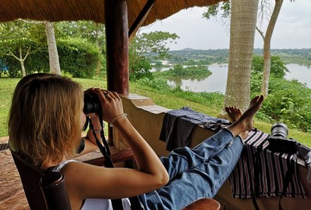 Uganda Familienurlaub - Uganda Family & Teens - Elisa Stoll mit Fernglas auf Terrasse der Lodge