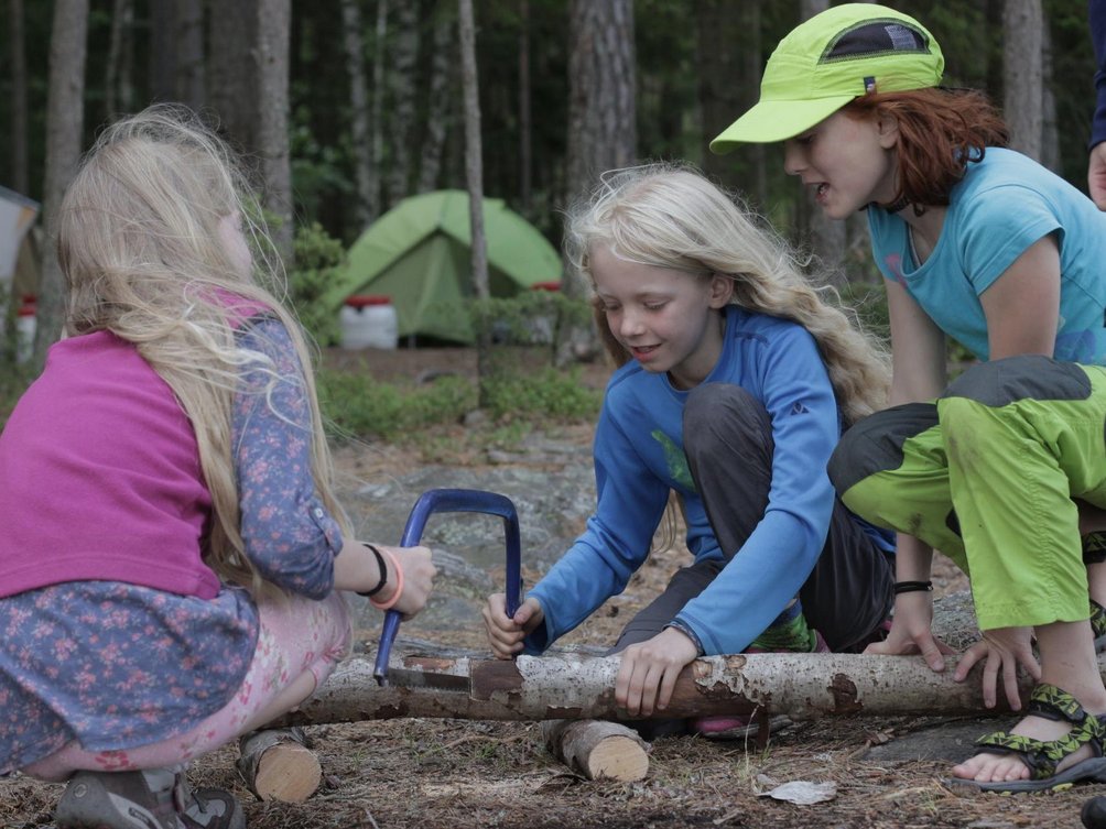 Kanu Urlaub mit Kindern - Kinder sägen Holzstamm