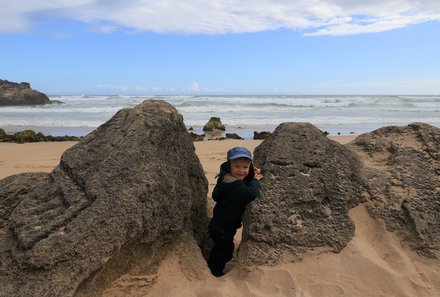 Garden Route Familienreise - Kind bei Felsen am Strand von Knysna