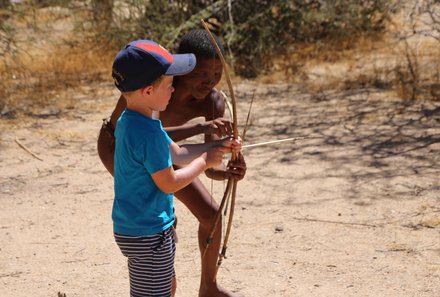 Fernreisen mit Kindern ab wann und wohin - Namibia Urlaub mit Kindern - Kind mit San Buschmann