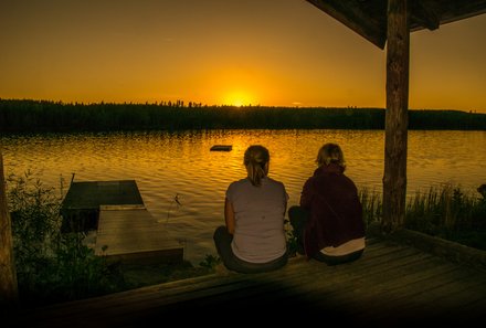 Schweden Familienreise - Schweden Family & Teens - Jugendliche sitzen an See bei Dämmerung