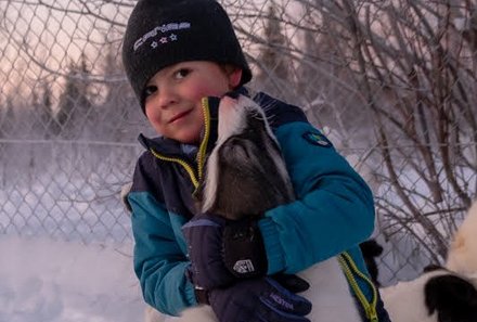 Schweden for family Winter - Hundeschlittentour - Kind mit Husky