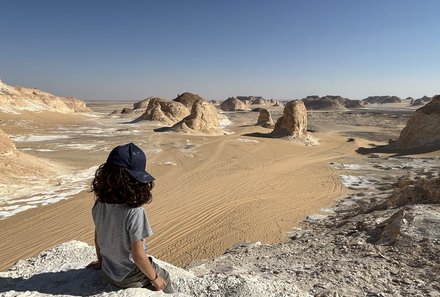 Kind sitzt auf der Weißen Wüste und genießt den Ausblick - Ägypten Reise mit Kindern