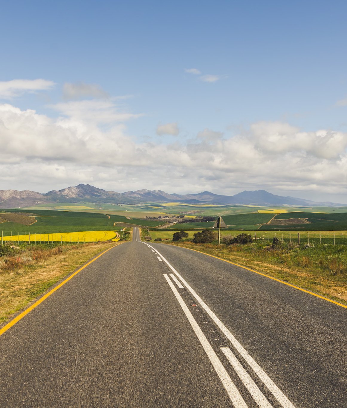 Südafrika Blog Artikel - Autostraße durch grüne Natur unter klarem Himmel – Südafrika mit Kindern