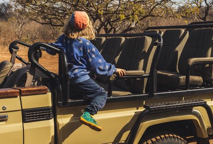 Südafrika Blog Artikel - Kind sitzt auf einem offenen Safari-Jeep – Südafrika Reise mit Kindern