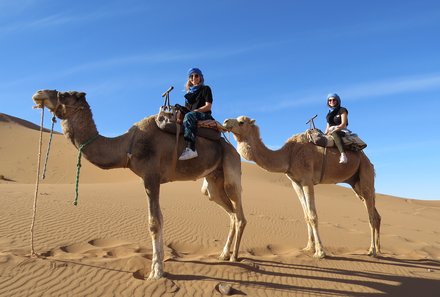 Marokko Rundreise für Familien - Erfahrungsbericht Marokko mit Teens - Teenager auf Kamelen in der Wüste
