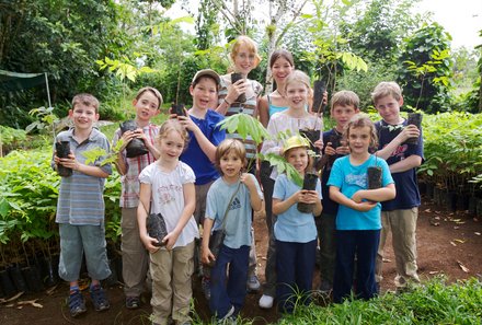 Costa Rica mit Kindern - Regenwaldprojekt: La Tigra Rainforest Lodge - Reisegruppe mit Bäumen in der Hand