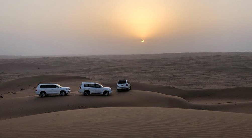 Oman Rundreise mit Kindern - Jeeps vor Sonnenuntergang in der Wüste