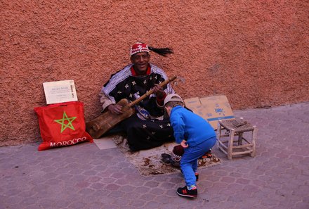 Marokko mit Kindern - Ein Tag in Marrakesch mit Kindern - Marokkanischer Straßenmusiker kriegt Geld