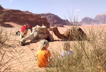 Fernreisen mit Kindern ab wann und wohin - Jordanien Urlaub mit Kindern - Kinder bei Kamelen in der Wüste