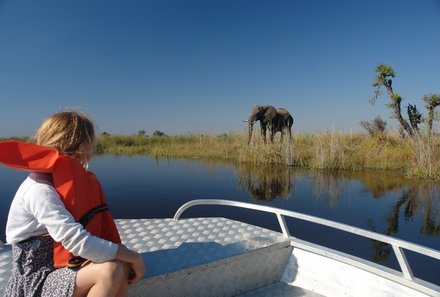 Botswana mit Kindern - Großeltern reisen mit Kindern - Boot und Elefant